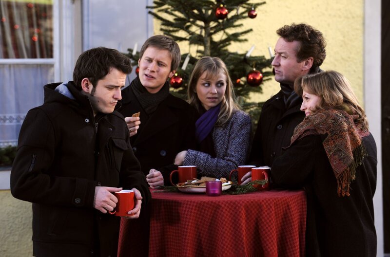 Vroni hofft, dass ihre Söhne Alfred bei einem gemeinsamen Treffen besser kennenlernen. Von links: Florian (Tommy Schwimmer), Ludwig Brunner (Martin Wenzl), Caro Ertl (Teresa Rizos), Alfred Knobloch (Hans Kitzbichler) und Veronika Brunner (Senta Auth). – Bild: BR/​Marco Orlando Pichler