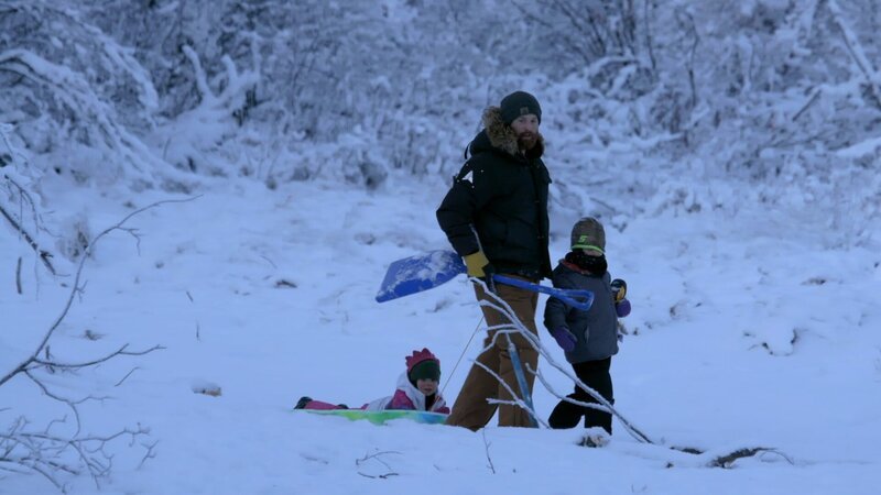 Kaleb Rowland spielt mit seinen beiden Kindern, Elovie und Gilbert, im Schnee (National Geographic/​Michael Cheeseman) – Bild: Copyright © The National Geographic Channel.