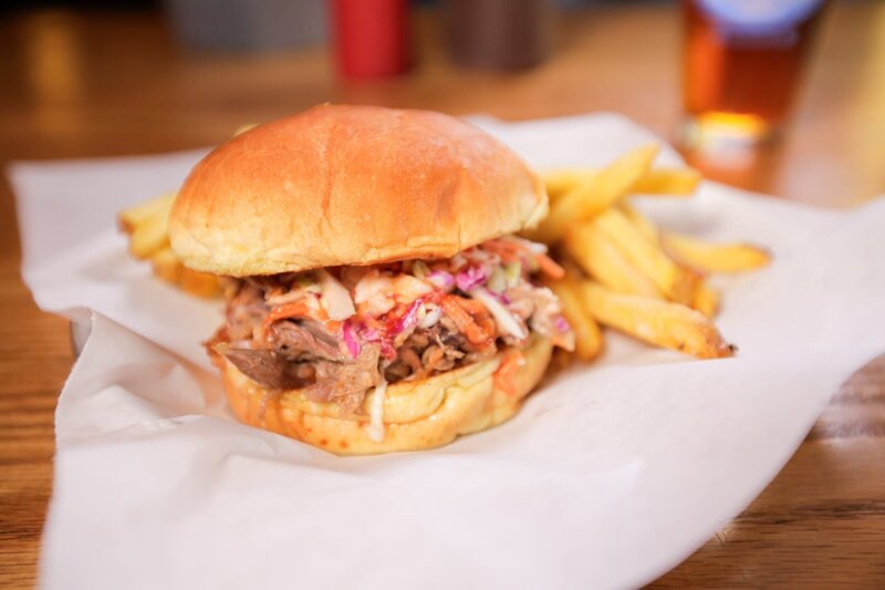 Pulled-Pork-Sandwiches werden bei „Martin’s BBQ“ frisch serviert, nachdem ein ganzes Schwein 24 Stunden lang auf dem hauseigenen Räucherofen geröstet wurde. – Bild: ORF/​Warner/​The Travel Channel