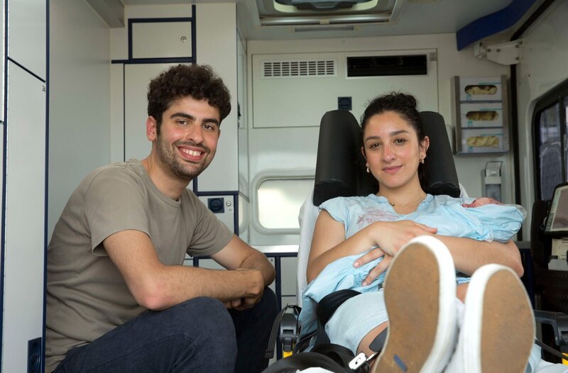 Eine Sturzgeburt mitten auf dem Parkplatz eines Baumarktes fordert die ungeteilte Aufmerksamkeit des Rettungsteams. Leonies (Acelya Seze, r.) Wehen haben auf dem Parkplatz begonnen. Lukas (Arda Görkem, l.) und Leonie sitzen nach der Geburt gesund im RTW. – Bild: ARD/​Volker Roloff
