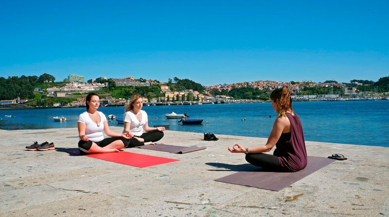 Hotelpraktikantin Alina Meinhard und Jungköchin Steffi Gehrlein machen in Porto einen Yoga-Kurs am Fluss. – Bild: BR/​Bewegte Zeiten GmbH