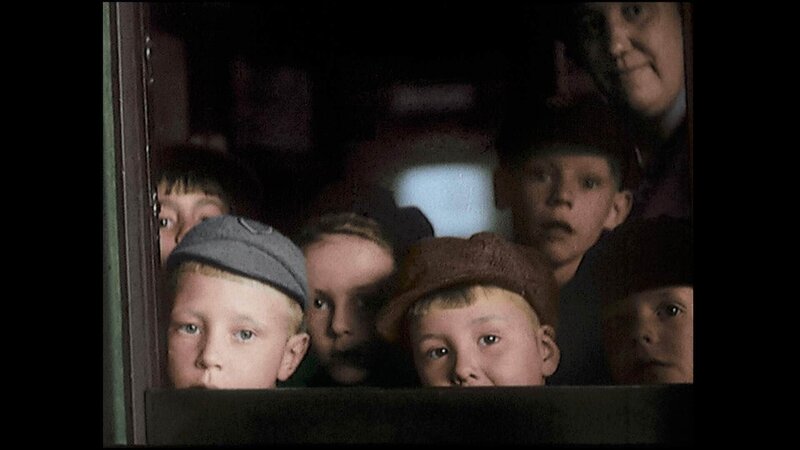 Kinder schauen aus dem Zugfenster, als sie evakuiert werden. – Bild: RTL /​ © Azor Producciones /​ Imperial War Museum