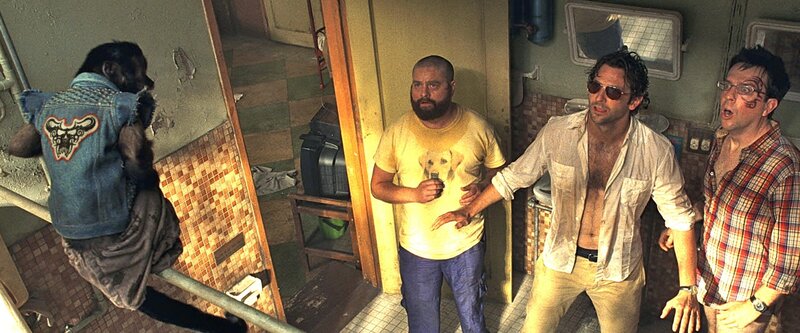 (v.l.) Alan (Zach Galifianakis), Phil (Bradley Cooper) und Stu (Ed Helms)wachen in einer total versifften, Kakerlaken verseuchten Bruchbude auf. Stu ziert jetzt ein Gesichts-Tattoo und Alan hat eine Glatze. Immerhin lauert im Bad kein Tiger, es turnt nur ein kettenrauchendes Kapuzineräffchen in Jeans-Jacke herum. – Bild: Warner Bros. Entertainment Inc. and Legendary Pictures – All Rights Reserved /​ Courtesy of Warner Bros. Picture /​ MKNS