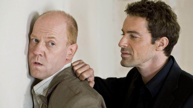 Chris (Gedeon Burkhard, re.) kann Bredow (Lutz Herkenrath) festnehmen. Aber kommen sie auch rechtzeitig, um Kowalski zu retten? – Bild: MG RTL D /​ Guido Engels