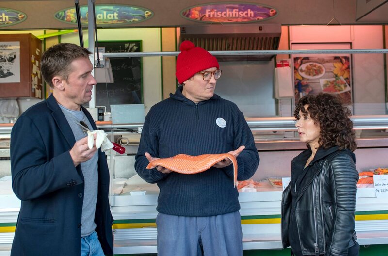 Jens Salm (Christian Ahlers, M.) wird beschuldigt, in den Wagen von Forellen-Flo auf dem Hamburger Fischmarkt eingebrochen zu sein. Piet Wellbrook (Peter Fieseler, l.) und  Harry (Maria Ketikidou, r.) müssen den Streithahn zum Reden bringen. – Bild: „Bild: ARD/​Kornelia Klein (S2). ARD-Programmdirektion/​Bildredaktion