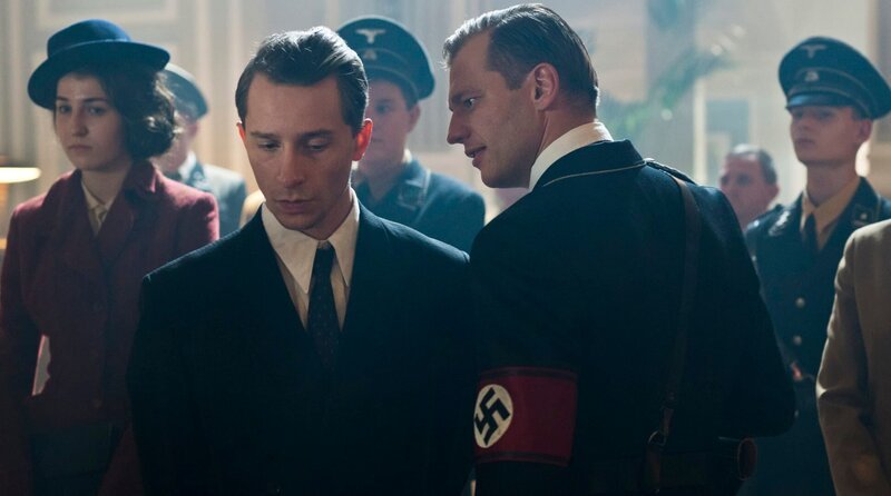 Emil Dreesen (Jonathan Berlin, vorne l.) ist im Visier von SA-Mann Senkert (David Hürten, vorne r.). – Bild: ARD Degeto/​SWR/​WDR/​Zeitsprung Film/​Krzysztof Wiktor