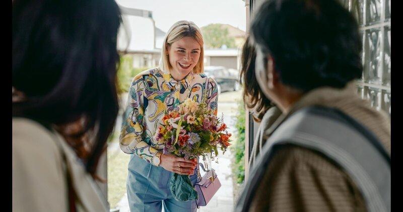 Franzi (Llewellyn Reichman, M.) überreicht den Eltern ihrer Freundin Blumen als Gast-Geschenk. – Bild: Honorarfrei – nur für diese Sendung inkl. SocialMedia bei Nennung ZDF und Hannah Aders.