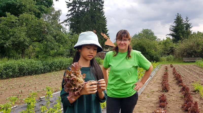 Betriebsleiterin Ines Küter begleitet Nhung auf ihrer Spurensuche auf einem Salatfeld in Brandenburg. – Bild: rbb/​Stefanie Fleischmann