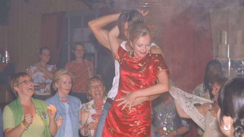 In der Bar wird Stefanie (Dana Golombek, M.) gleich von einem gut gebauten Tänzer auf die Bühne gezogen. Von den anderen angefeuert, findet sie sich schon bald beim heißen Tanz wieder … – Bild: MG RTL D