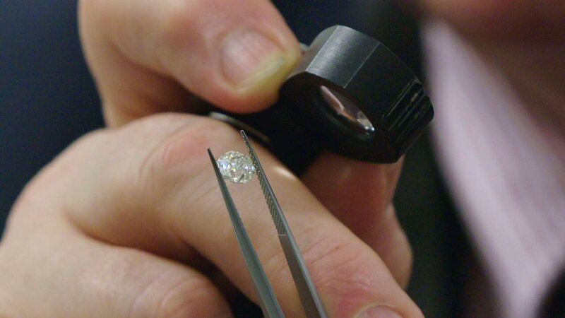 Eine Person schaut sich einen Diamanten an – Bild: cinflx /​ Crime + Investigation /​ Rare Television Ltd.
