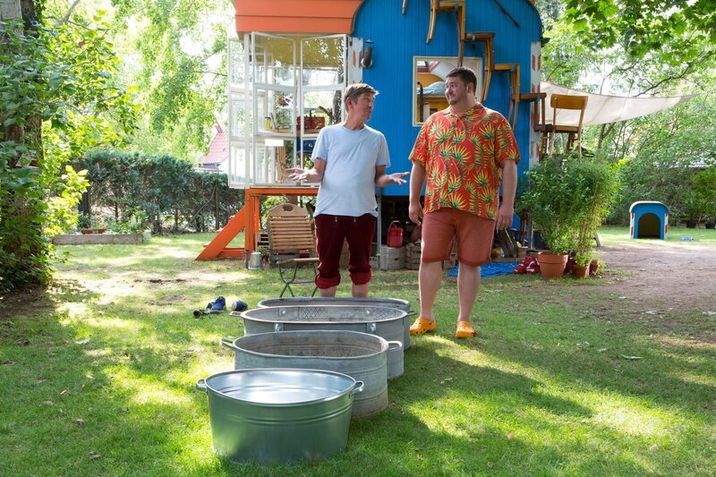 Wohltat oder einfach nur eklig? Fritz Fuchs (Guido Hammesfahr, l.) versucht Nachbarn David Paschulke (Daniel Zillmann, r.) für seinen selbstgebauten Barfußpfad zu begeistern. – Bild: ZDF und Zia Ziarno