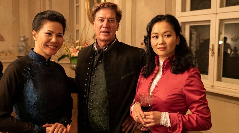 Gutsherr Otto von Glanzberg (Tobias Moretti, Mitte) mit seiner Verlobten Dan-Linh (Yvonne Yung Hee Bormann, r.) und ihrer Mutter Ho (Hang Tran Thanh). – Bild: ARD Degeto Film/​Allegro Film/​Toni Muhr
