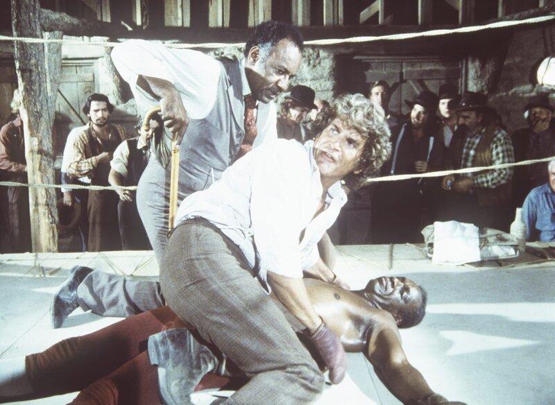 (v.l.n.r.) Manager Moody (Raymond St. Jaques) und Charles Ingalls (Michael Landon) stellen besorgt fest, dass Joe Kagan (Moses Gunn) nach dem K.o.-Schlag nicht mehr aufsteht. – Bild: Worldvision