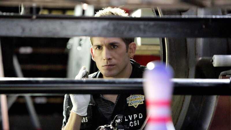 Ein Bowlingturnier wurde jäh unterbrochen, als im letzten Durchgang statt der Bowlingkugel der Kopf eines Angestellten aus der Ballausgabe kullert. Greg (Eric Szmanda) sucht hinter der Bowlingbahn nach dem Körper des Opfers. – Bild: MG RTL D /​ CBS