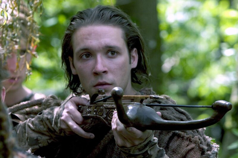 The team visits M7G-677, a primitive world where no one is over 24 years old, because of ritual suicides they believe keep the Wraith at bay. McKay discovers that they are in fact being protected by an Ancient electromagnetic shield. He takes the ZPM powering it, unwittingly allowing a long-dormant Wraith transmitter to reactivate. – Bild: MGM