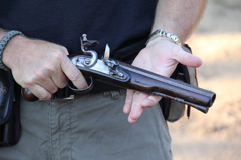 A close-up of a flintlock pistol in Sean Rich’s hands as he expertly inspects it. – Bild: National Geographic