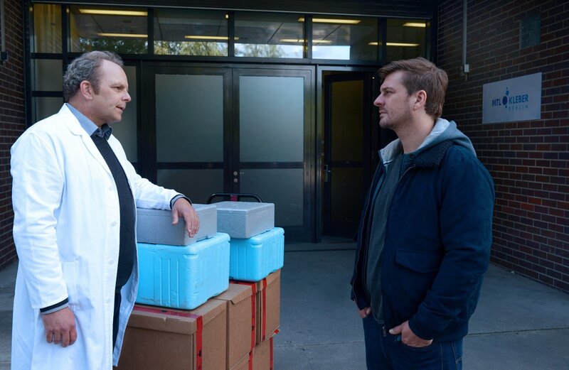 Sebastian Klöckner (Matthi Faust, r.) erfährt von dem Apotheker Robert Kleber (Andreas Schröders, l.), dass er die Arztpraxis der Ermordeten regelmäßig mit Medikamenten versorgt hat. – Bild: Katrin Knoke /​ ZDF Enterprises GmbH