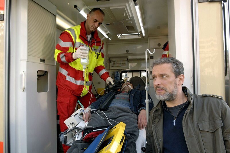 Bevor Jaecki (Uli Drewes, liegend) Ulrich (Wolfgang Wagner, r.) den Namen von dem Verräter sagen kann, bricht er plötzlich bewusstlos zusammen … – Bild: SAT.1 /​ Claudius Pflug Eigenproduktionsbild frei
