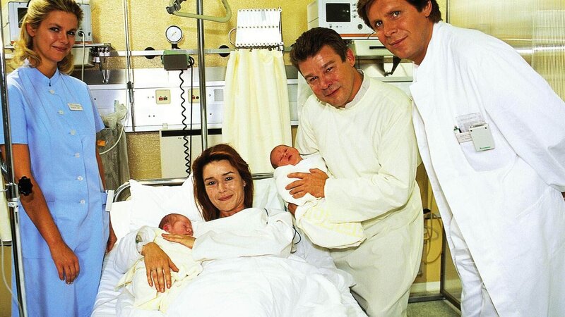 Dr. Frank (Sigmar Solbach, re.) beglückwünscht die Eltern Frau und Herrn Steigner (Constanze Roeder und Werner Asam) zu den gesunden Zwillingen. (Links: Claudia Lösel als Krankenschwester Susi) – Bild: MG RTL D /​ Elke Werner