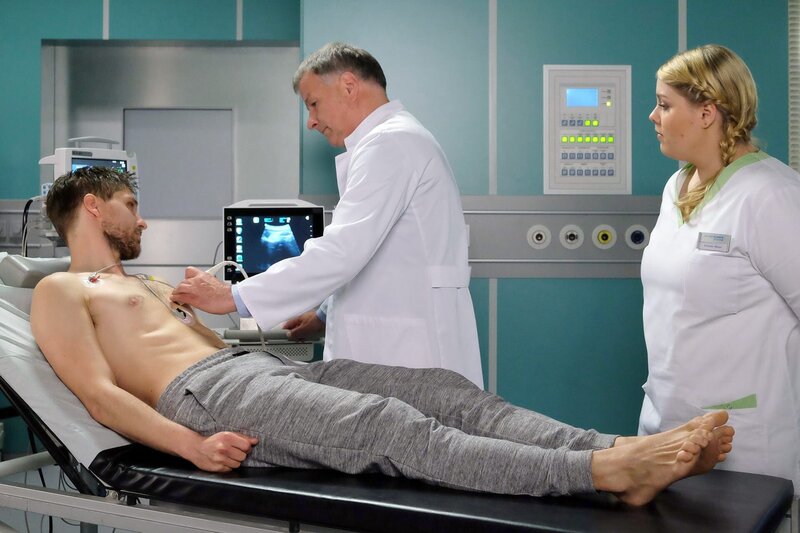 Schwester Miriam hat John Neyers bewusstlos in seinem Zimmer gefunden. Beim Ultraschall stellt Dr. Roland Heilmann fest, dass Johns Herz sehr vergrößert ist. – Bild: BR/​MDR/​Saxonia Media Filmproduktions GmbH/​Sebastian Kiss