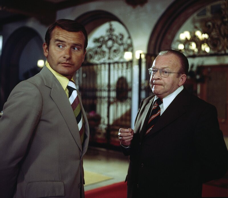 Heines übernimmt im Laufe der Routinebefragungen über den Unglücksfall auf dem nahen See den Internatsdirektor Schleyer. (Reinhard Glemnitz, Joachim Wichmann). – Bild: ZDF /​ Neue Münchner Filmprod.