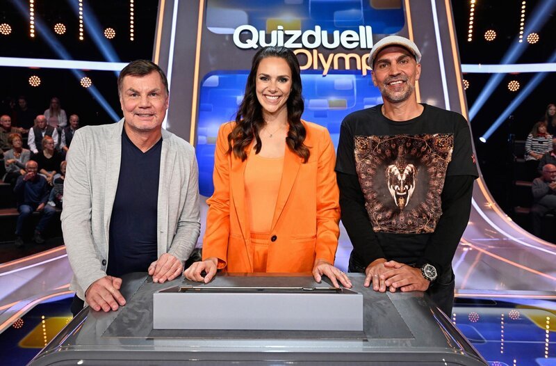 Quizmasterin Esther Sedlaczek (M.) mit den Kandidaten des Teams „Fussball“: Thomas Helmer (l.) und Markus Babbel (r.), beide Ex-Fußballprofis. – Bild: ARD/​Markus Hertrich