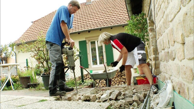 Susanne und Patrick wollen sich einen schicken Schwenkplatz im Garten bauen. Eine neuangelegte Terrasse dient dabei als Fläche und der alte Carport wird kurzer Hand zum Dach umfunktioniert. – Bild: RTL II