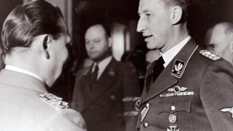 Für die Nazis der perfekte Nationalsozialist: Reinhard Heydrich (r., 1904⁠–⁠1942) wurde 1941 von Hermann Göring (l.) mit der „Endlösung der Judenfrage“ beauftragt. Am 20.01.1942 hat Heydrich die Organisation und strukturierte Umsetzung seines Auftrags mit allen beteiligten Behörden auf der ‚Wannseekonferenz‘ koordiniert. – Bild: TVNOW /​ Spiegel TV