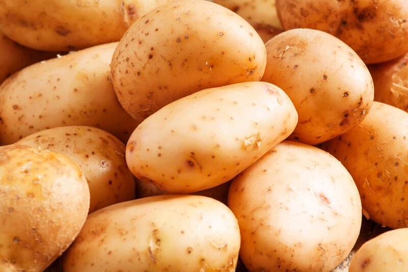 Fresh potatoes in an old wooden table, selective focus – Bild: Olga Kochina