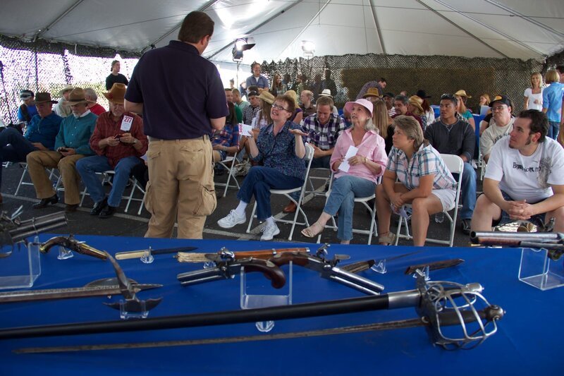 A table full of antique weapons behind him, Sean Rich speaks to one of the patrons at the auction. – Bild: National Geographic Channels