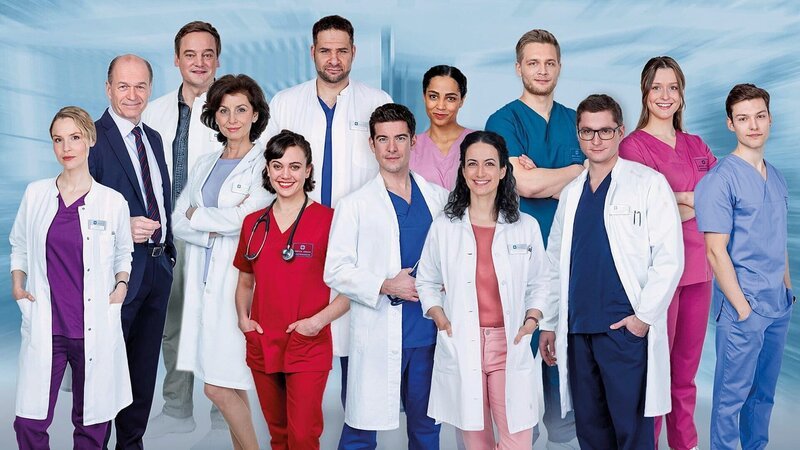 In aller Freundschaft – Die jungen Ärzte Staffel 7 Das Team: v.l.n.r. hintere Reihe: Horst Günter Marx als Wolfgang Berger, Christian Beermann als Dr. Marc Lindner, Mike Adler als Dr. Matteo Moreau, Elisa Agbaglah als Dr. Emma Jahn, Luan Gummich als Mikko Rantala, Isabella Krieger als Viktoria Stadler, Lion Wasczyk als Florian Osterwald. vordere Reihe: Mirka Pigulla als Dr. Julia Berger, Marijam Agischewa als Prof. Dr. Karin Patzelt, Milena Straube als Rebecca Krieger, Philipp Danne als Dr. Ben Ahlbeck, Sanam Afrashteh als Dr. Leyla Sherbaz, Stefan Ruppe als Dr. Elias Bähr. – Bild: SRF/​ARD