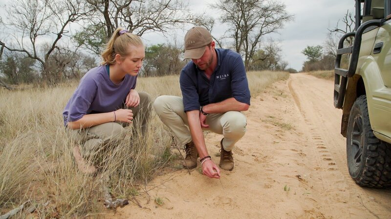Nina und Willem Pietersen stoßen auf den Pfotenabdruck eines Löwen. – Bild: BR/​Text und Bild Medienproduktion GmbH & Co. KG/​Christoph Schimmelpfennig