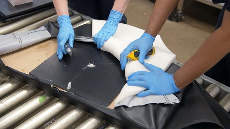 Die CBP Supervisory Officers Keller und Pirollo zerlegen in Philadelphia einen verschifften Ottomanen und finden eine weiße, pulverförmige Substanz in der Auskleidung. (National Geographic) – Bild: National Geographic /​ Disney