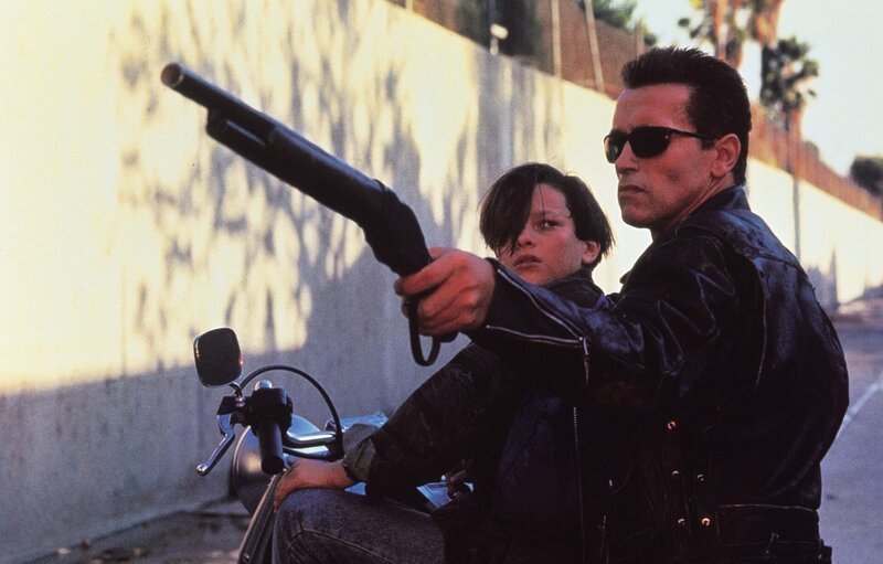 Der Android T-800 (Arnold Schwarzenegger) und sein Schützling John Connor (Edward Furlong). – Bild: Warner TV Serie