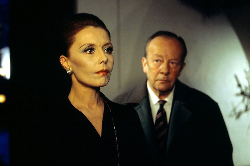 Irene Triberg lebt in einer Umgebung, wie sie sich nur ein begütertes Künstlerehepaar leisten kann: Ein schönes Haus, Bücher, Schallplatten alles, was der geistigen Anregung dienen kann. Deshalb wirkt der Besuch von Kommissar Keller wie der Einbruch in eine fremde Welt. Honorarfrei – nur für diese Sendung bei Nennung ZDF und Neue Münchner Fernsehproduktion – Bild: ZDF und Neue Münchner Fernsehproduktion /​ Neue M¸nchner Fernsehproduktion