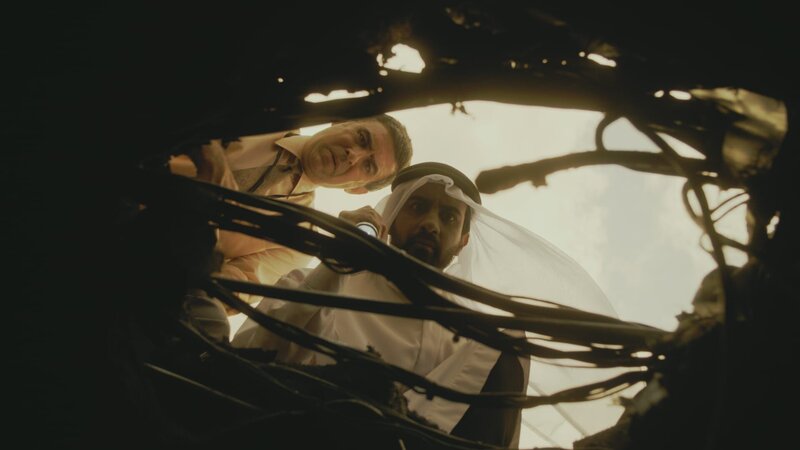 REENACTMENT – Bei der Untersuchung des Wracks von Saudia-Flug 163 entdecken die Ermittler (gespielt von Martin Sims und Farid Yazdani) ein Loch im Kabinenboden, das darauf hindeutet, dass das Feuer, das alle 301 Menschen an Bord getötet hat, möglicherweise im darunter liegenden Frachtraum ausgebrochen ist. – Bild: Cineflix
