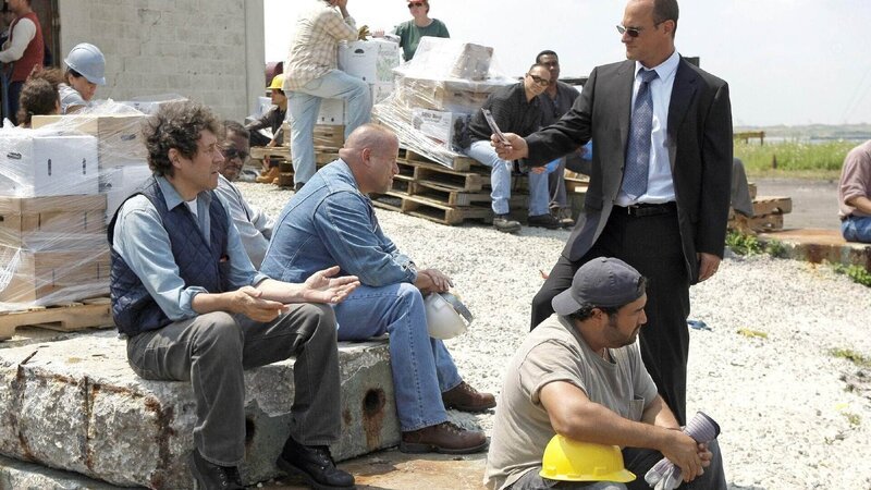 Det. Stabler (Christopher Meloni, r.) befragt Hafenarbeiter – unter anderem Callum Donovan (Stephen Rea, l.) nach einer vermissten Frau. Diese soll angeblich von einem Hafenarbeiter entführt worden sein. – Bild: TVNOW /​ NBC Universal