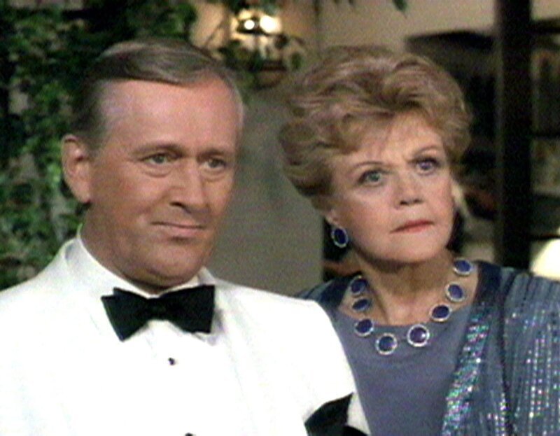 Jessica Fletcher (Angela Lansbury) hilft ihrem alten Freund, dem Geheimagenten Michael Hagarty (Len Cariou), bei einem Auftrag. Sie begleitet ihn bei einer Party als seine Ehefrau. – Bild: Warner TV Serie