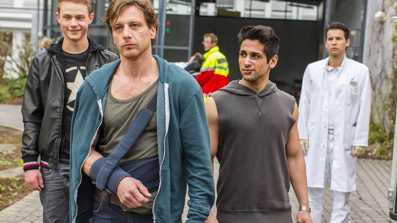 Stefan (Hendrik Duryn, vorne) verlässt mit Finn (Dennis Mojen, l.) und Cem (Daniel Rodic) die Klinik und lässt Karins Freund Christoph Neumann (Florian M. Odendahl), der nun von dem Kuss zwischen Stefan und Karin weiß, einfach stehen. – Bild: TVNOW /​ Frank Dicks