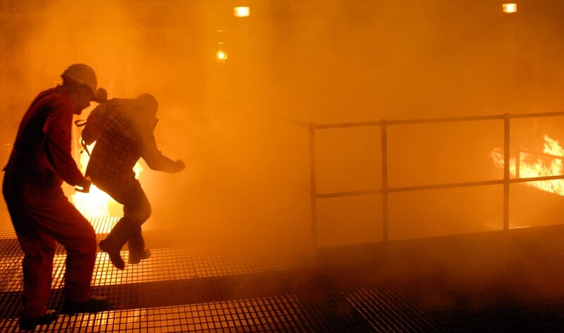 DRAMATIC REENACTMENT: Two oil rig workers on the Deepwater Horizon fight through the smoke and firestorms raging all around them. In April, 2010, a combination of mud, methane gas and water erupted on the rig. The material soon became fully gaseous, ignited, and a series of explosions and firestorms brought the rig eventually to the bottom of the Gulf of Mexico. – Bild: Darlow Smithson Productions Ltd