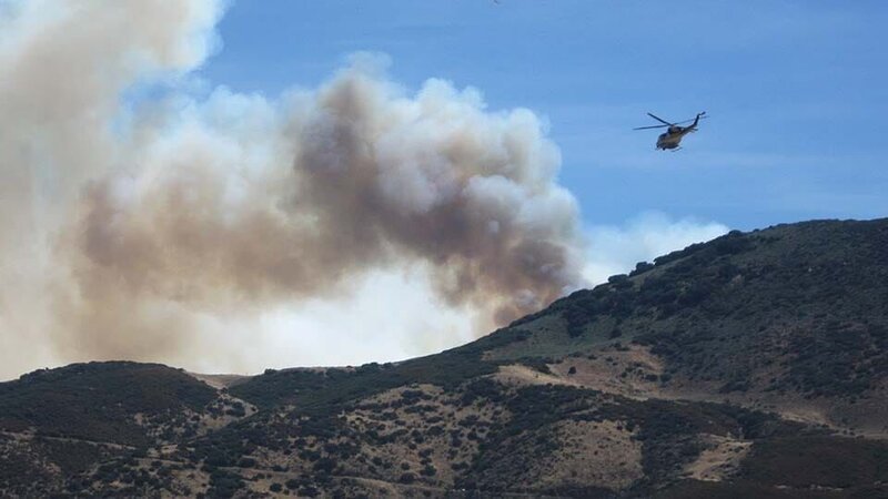 A fire helicopter prepares to make a water drop over the Tehachapi fire. – Bild: Discovery Communications Inc., 44 Blue Productions, Inc.