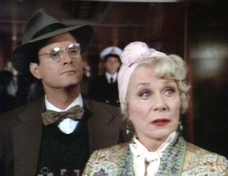 Die Kriminalschriftstellerin Lady Abigail Austin (June Havoc) und der junge Journalist Christy McGinn (Gary Kroeger) wollen gemeinsam den Mord an Bord der „Queen Mary’ aufklären. – Bild: Warner TV Serie