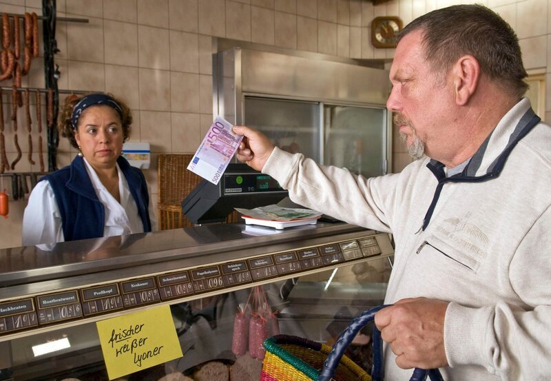 Der stumme Skipper Erich (Heinz Werner Kraehkamp) ist im Dorf unbeliebt und soll nicht bedient werden. So bietet er der Metzgerin Lilly (Franziska Traub) 500 Euro für eine Wurst. – Bild: SWR/​ARD Degeto/​Manuela Meier