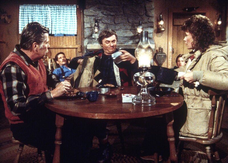 Weihnachtsparty mit KGB-Agenten: Amanda (Kate Jackson, r.) hat einen Waffenstillstand vereinbart, um den verletzten Lee (Bruce Boxleitner, hinten) zu retten. – Bild: CBS Television