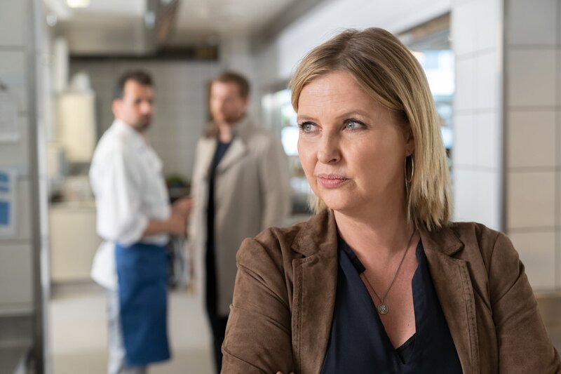Vera Lanz (Katharina Böhm), im Hintergrund stehen zwei Männer. – Bild: ORF