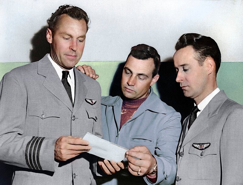 L-R: Piloten E.J. Smith, Kenneth Arnold und Ralph E. Stevens sehen sich ein Foto eines nicht identifizierten Flugobjekts an, das sie auf dem Weg nach Seattle, Washington, gesehen haben. – Bild: The History Channel
