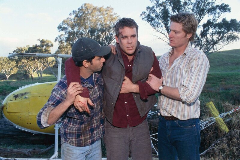 Alberto (Ben Mortley, l.) und Nick (Brett Tucker, r.) helfen dem verletzten Alex (Aaron Jeffery) auf die Beine. – Bild: RTL /​ Southern Star/​PK