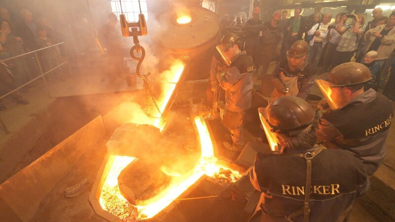 Die Herstellung von Glocken – Fachkräfte gießen eine Glocke. – Bild: MG RTL D