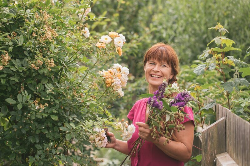 Moderatorin Sabrina Nitsche beim Schneiden eines sommerlichen Blumenstraußes im Querbeet-Garten. – Bild: ZDF und Lisa Hinder
