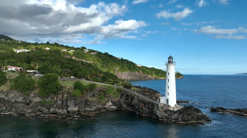 Der Leuchtturm von Vieux-Fort: Er thront ganz im Süden der Insel Basse-Terre auf einer Klippe und gehört zu den Lieblingsorten für Wanderer, aber auch Surfer pilgern gerne hierher, um einen Ritt auf der Welle zu wagen. – Bild: NDR/​Julian Ringer